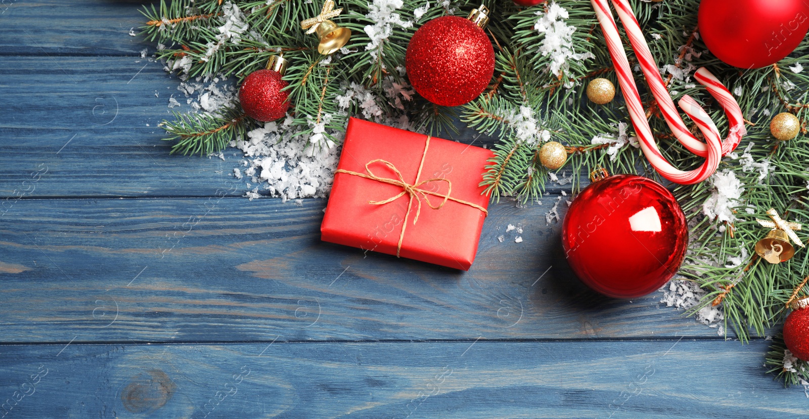 Photo of Fir tree branches with Christmas decoration on blue wooden background, flat lay. Space for text