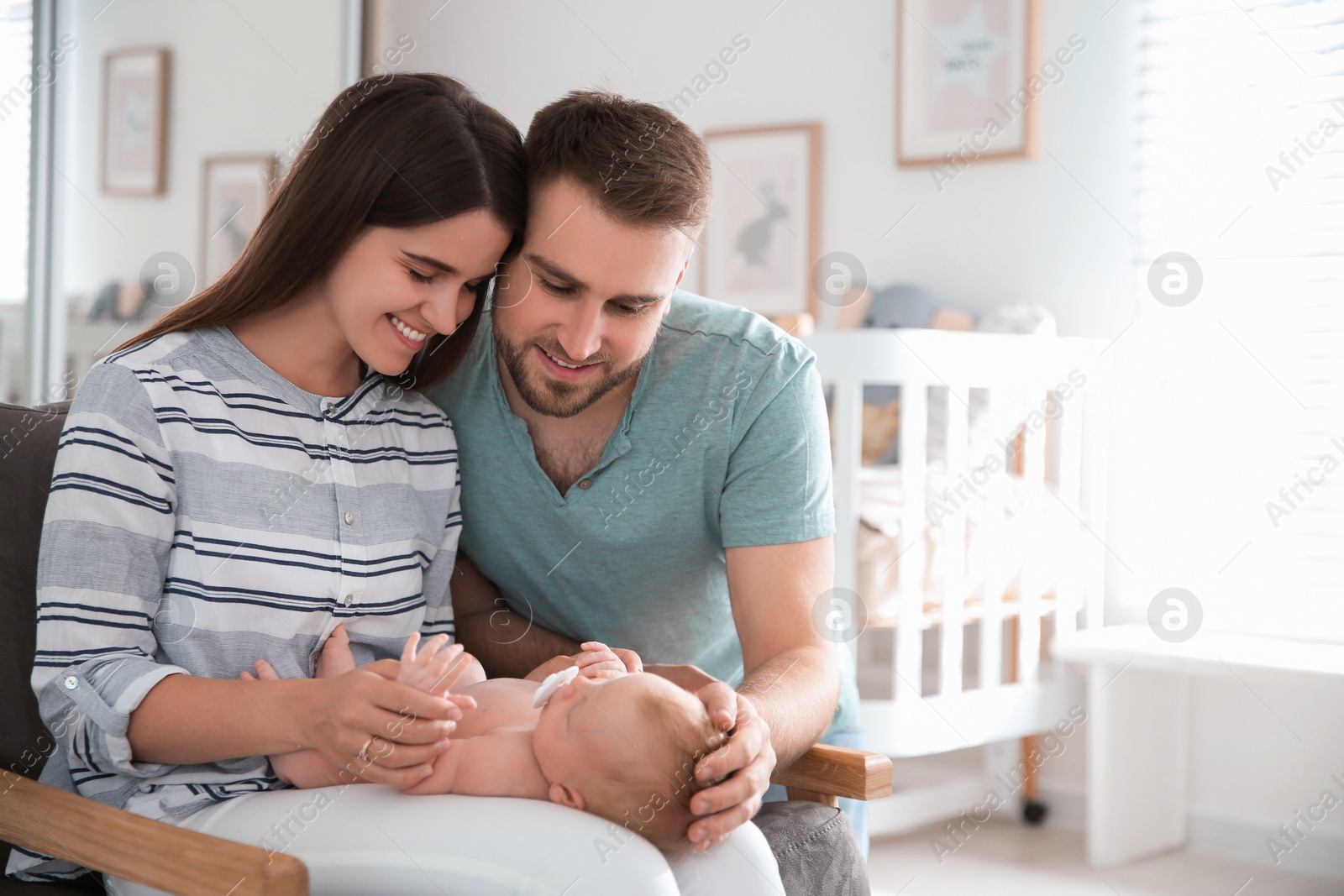 Photo of Happy couple with their newborn baby at home