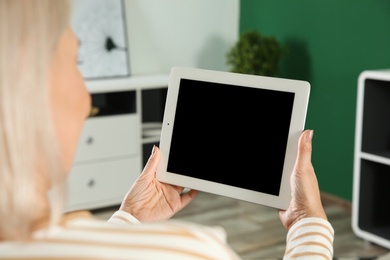 Photo of Woman using video chat on tablet at home, closeup. Space for text