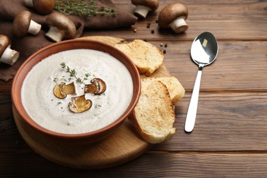 Photo of Fresh homemade mushroom soup served on wooden table. Space for text