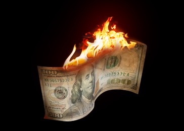 Image of One hundred dollar banknote burning on black background