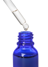 Photo of Blue bottle and dropper with essential oil on white background