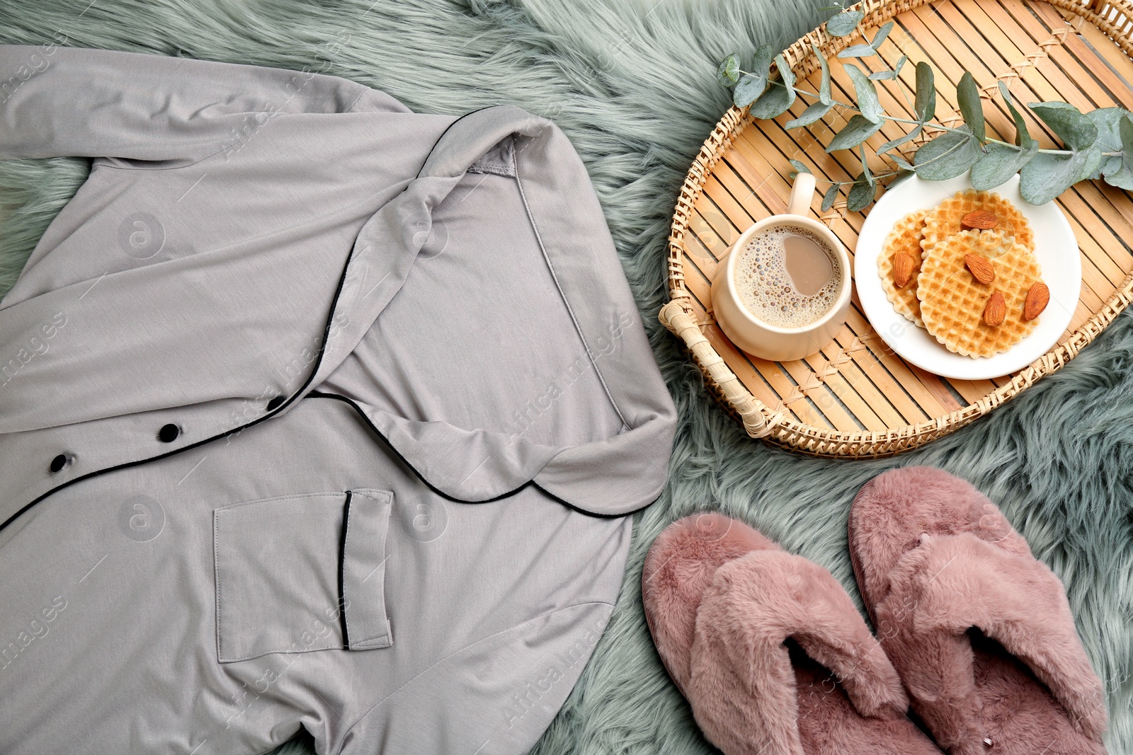 Photo of Flat lay composition with fluffy slippers and pajamas on fuzzy carpet. Comfortable home outfit