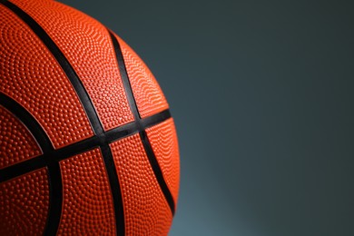 One orange basketball ball on dark grey background, closeup. Space for text