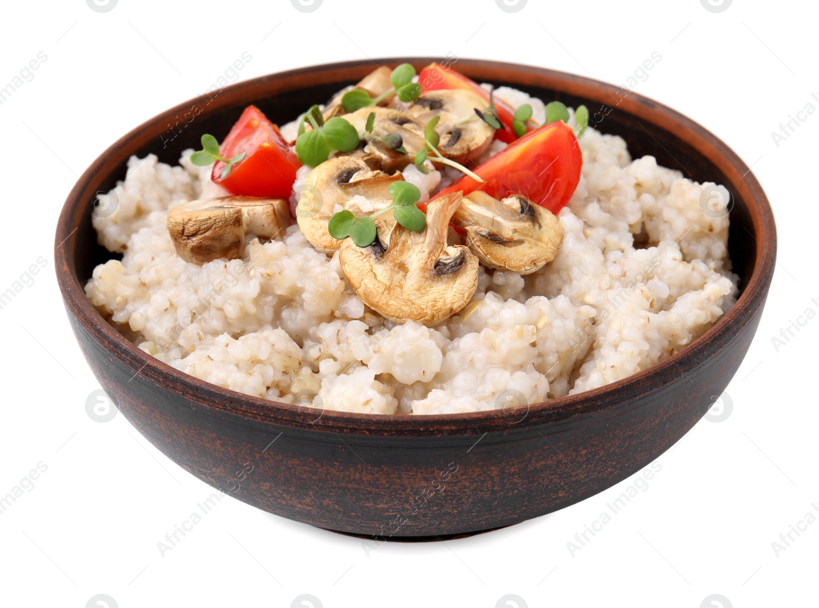Photo of Delicious barley porridge with mushrooms, tomatoes and microgreens in bowl isolated on white
