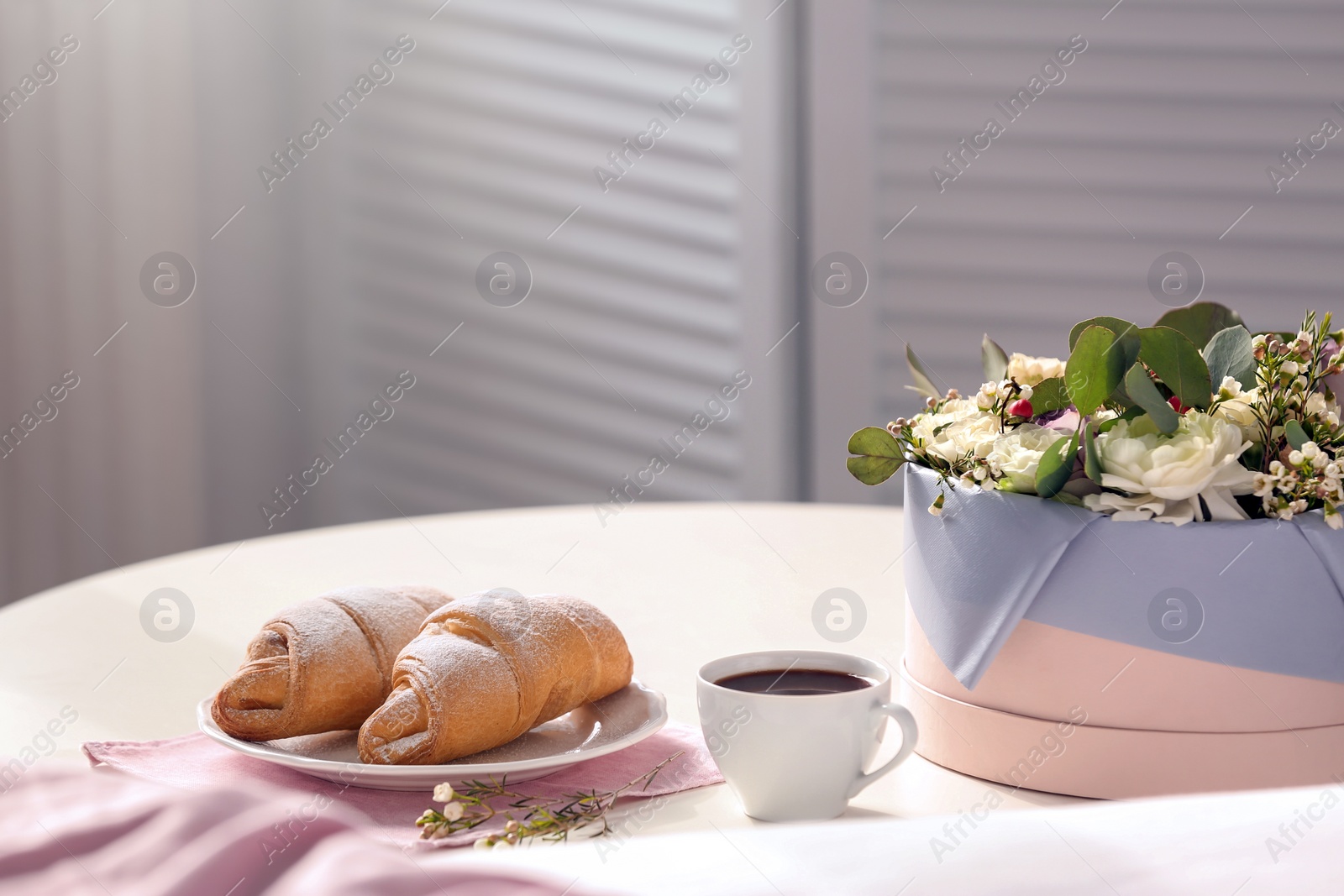 Photo of Plate with delicious croissants and cup of coffee on table