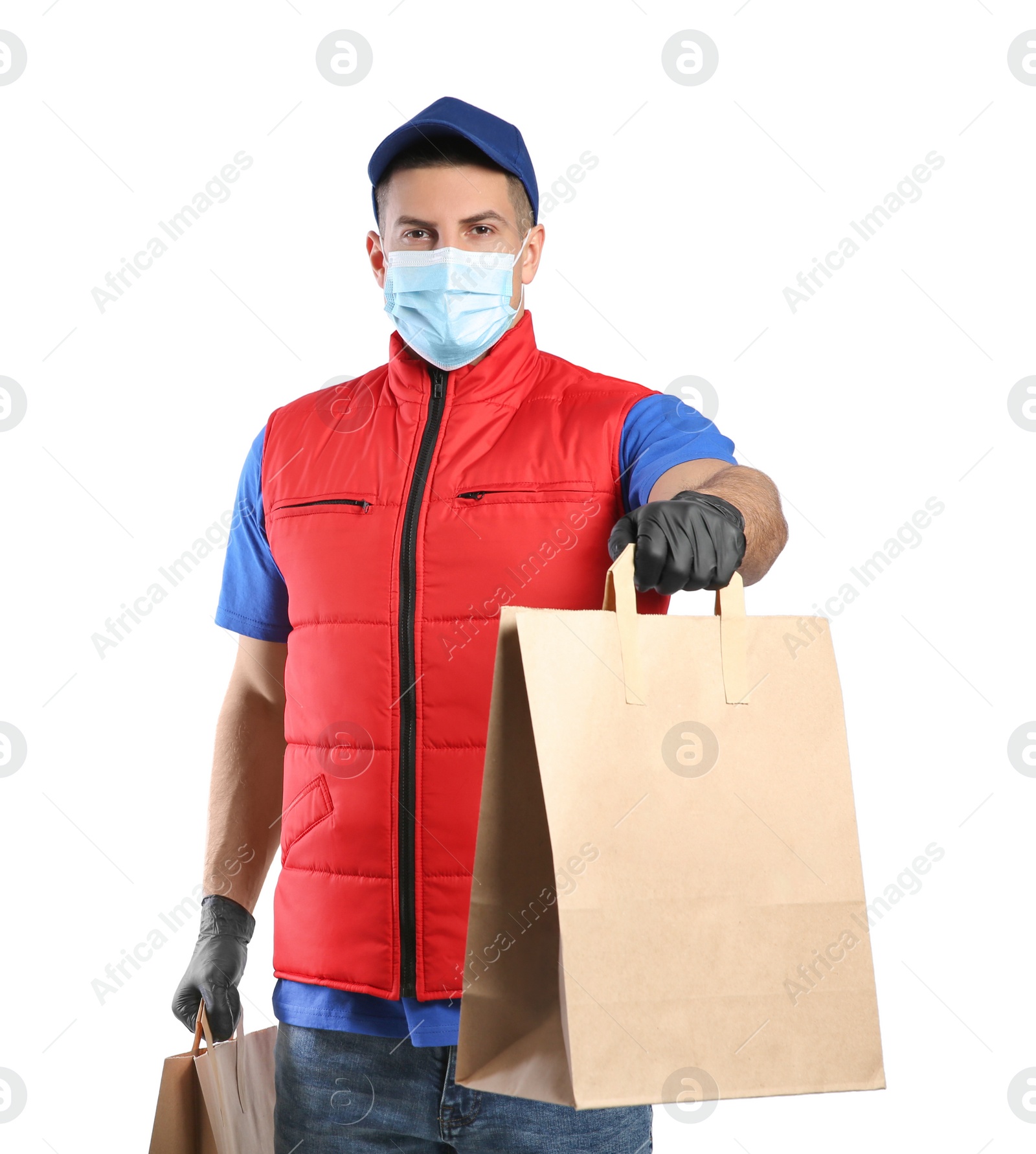 Photo of Courier in medical mask holding paper bags with takeaway food on white background. Delivery service during quarantine due to Covid-19 outbreak