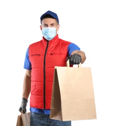Photo of Courier in medical mask holding paper bags with takeaway food on white background. Delivery service during quarantine due to Covid-19 outbreak
