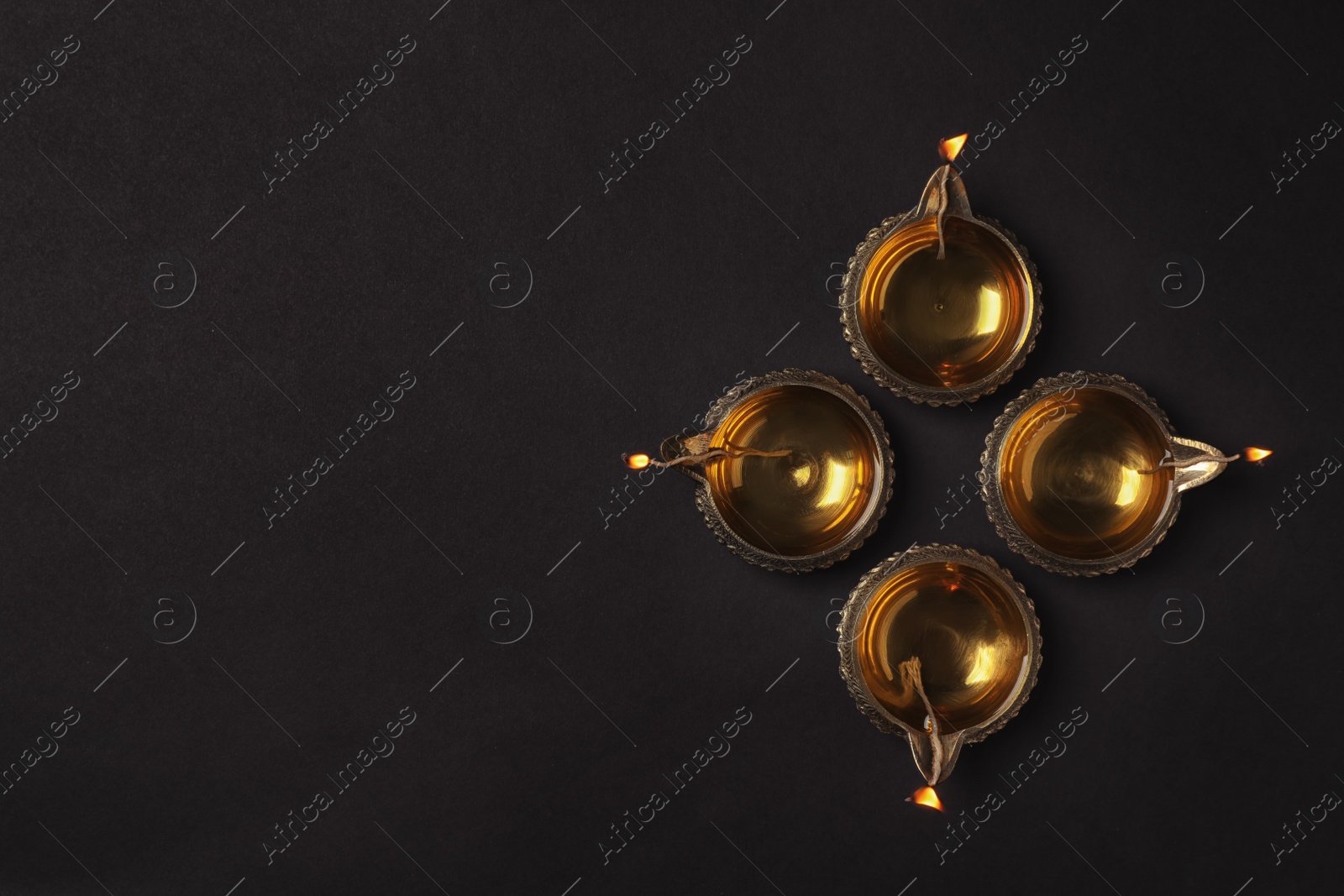 Photo of Diwali diyas or clay lamps on dark background, top view