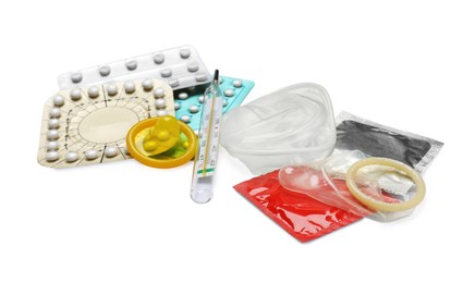 Contraceptive pills, condoms and thermometer isolated on white. Different birth control methods
