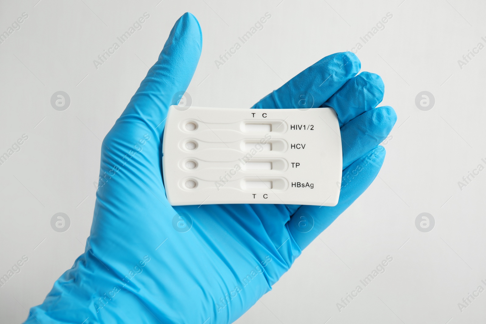 Photo of Doctor holding disposable express test for hepatitis on white background, closeup