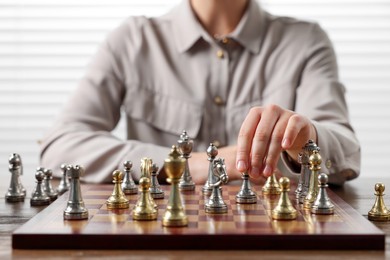 Photo of Woman playing chess during tournament at table, closeup