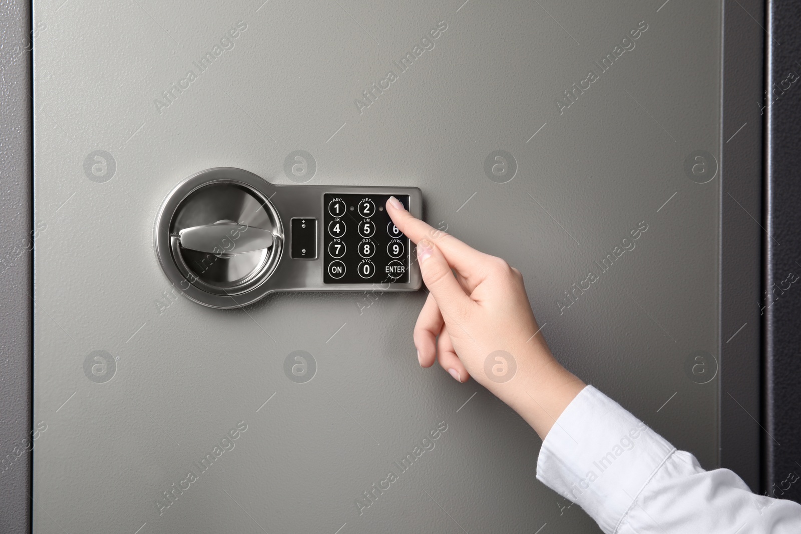 Woman opening steel safe with electronic lock, closeup Photo of Woman opening steel safe with electronic lock, closeup