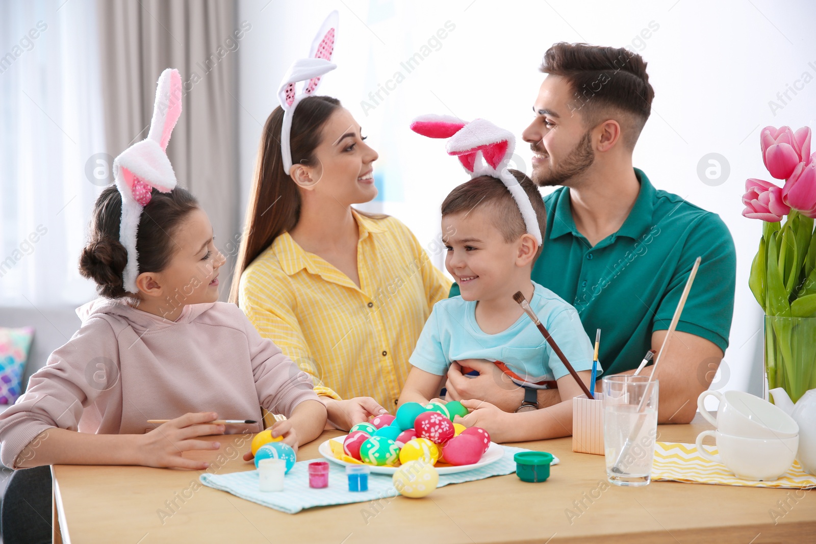 Photo of Happy family with Easter eggs at home. Festive tradition