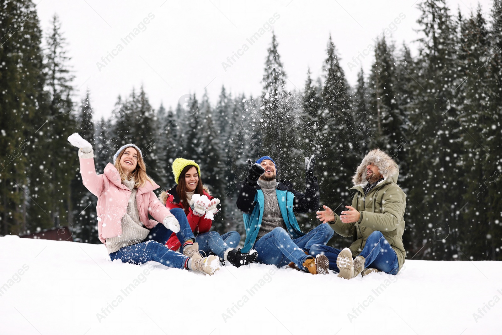 Photo of Group of friends playing with snow outdoors. Winter vacation