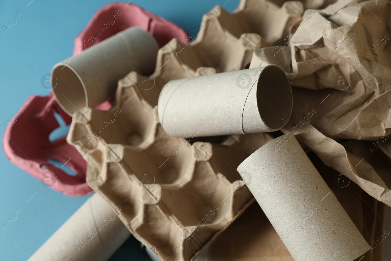 Photo of Different waste paper on light blue background, closeup