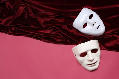 Theater arts. White masks and red fabric on pink background, top view. Space for text