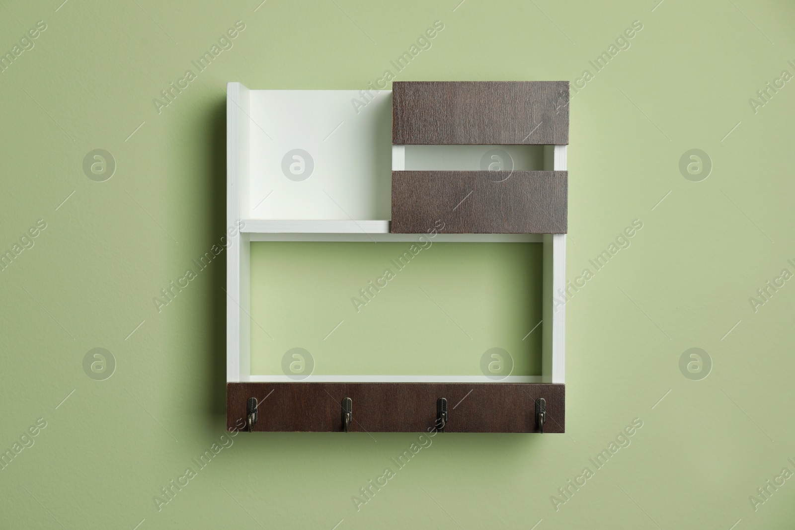 Photo of Wooden hanger for keys on light green wall