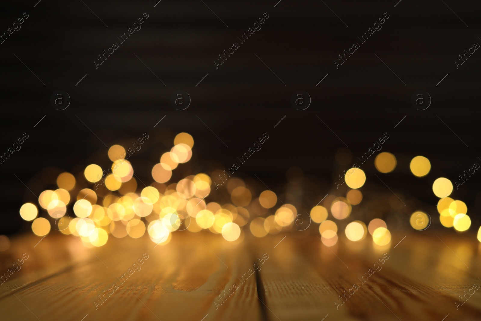 Photo of Empty wooden surface and blurred lights on background. Bokeh effect