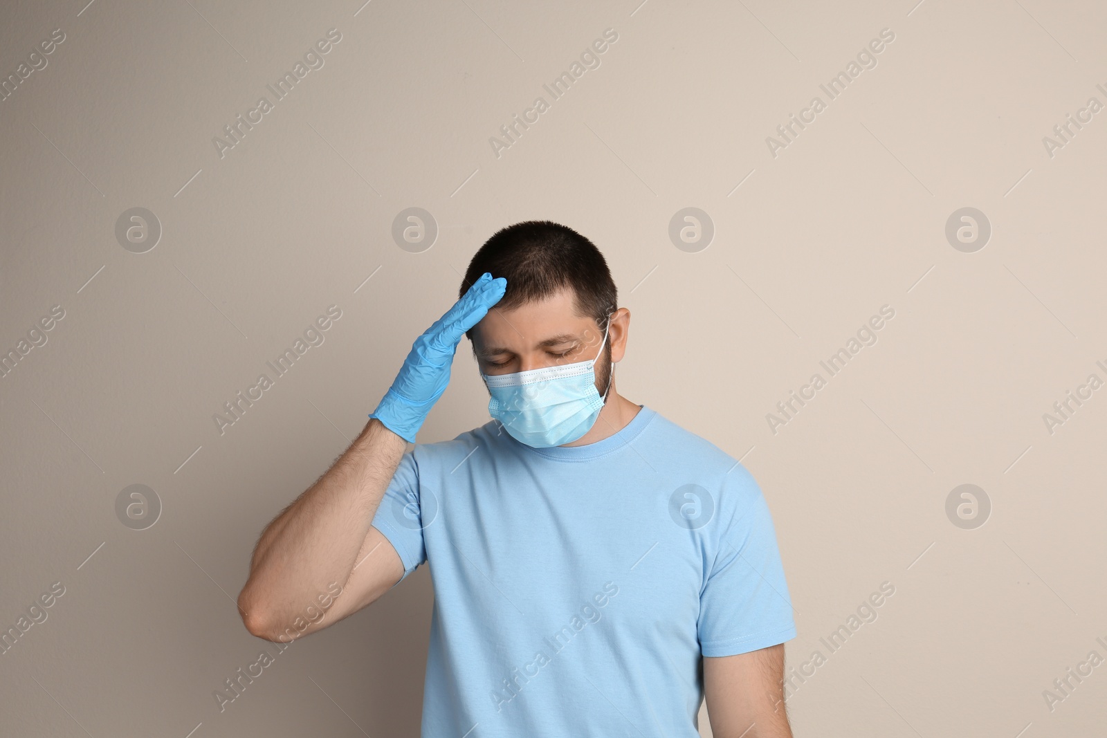 Photo of Stressed man in protective mask on beige background. Mental health problems during COVID-19 pandemic