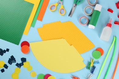Photo of Flat lay composition with different materials to create party hats on light blue background. Handmade decoration