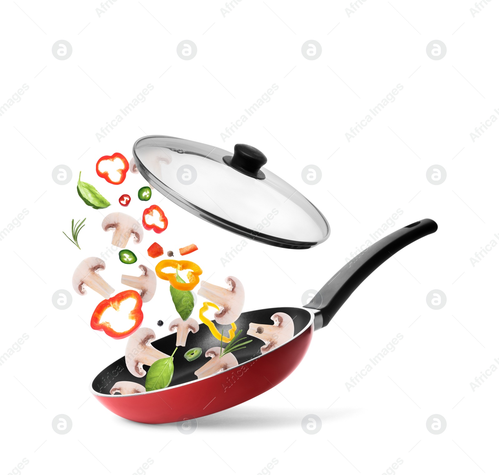 Image of Different vegetables and mushrooms falling into frying pan on white background. Process of cooking