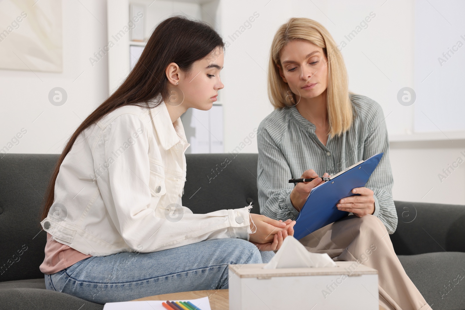 Photo of Psychologist working with teenage girl in office. Teenager problems