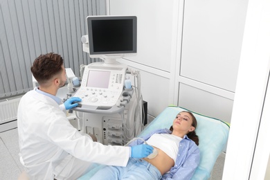 Photo of Doctor conducting ultrasound examination of patient's abdomen in clinic