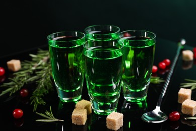 Photo of Absinthe in shot glasses, cranberries, rosemary and brown sugar on mirror table. Alcoholic drink