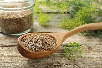 Photo of Dry seeds and fresh dill on wooden table, closeup. Space for text