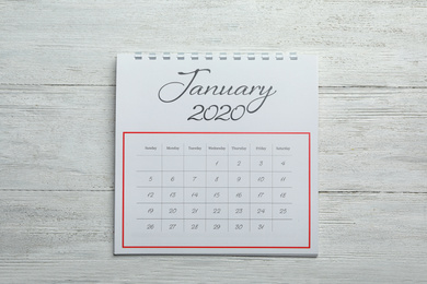 Photo of January 2020 calendar on white wooden background, top view