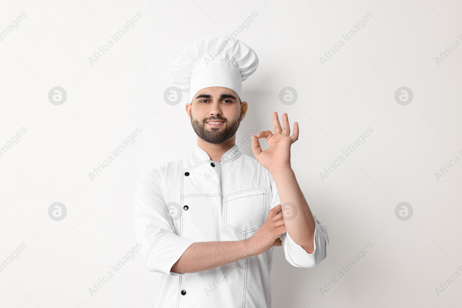 Photo of Professional chef with showing OK gesture on white background