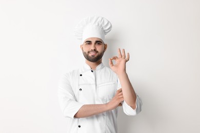 Professional chef with showing OK gesture on white background