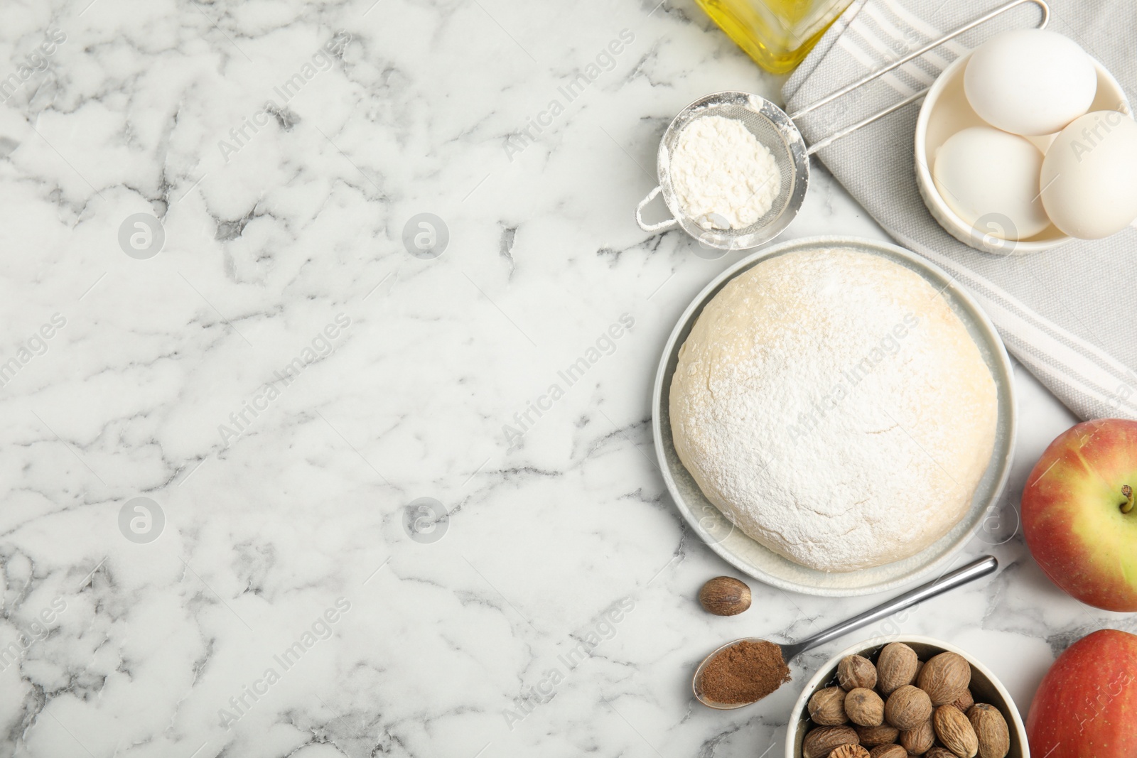 Photo of Raw dough, nutmeg seeds and other ingredients on white marble table, flat lay. Space for text