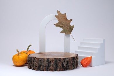 Stylish presentation for product. Wooden stump, geometric figures and autumn decor on white background