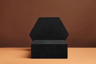 Photo of Black geometric figures on brown background. Stylish presentation for product