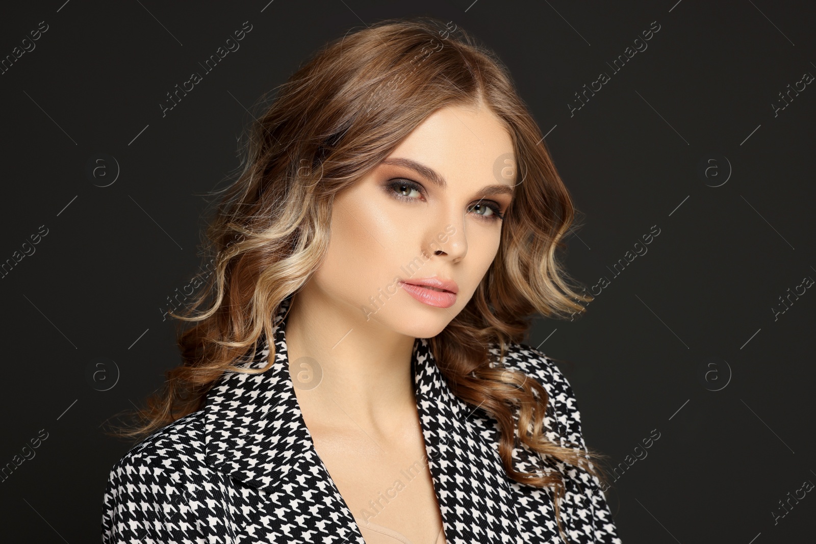 Photo of Portrait of young woman with beautiful makeup on black background