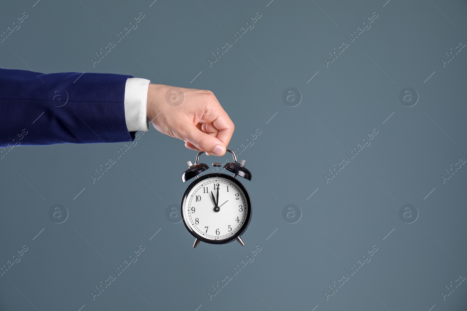 Photo of Young businessman holding clock on color background. Time management