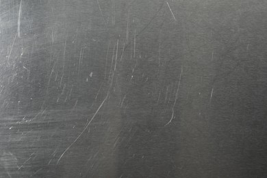 Photo of Old metal surface with scratches as background, closeup