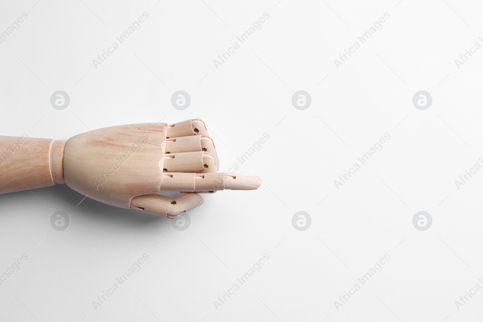 Photo of Wooden mannequin hand on white background, top view