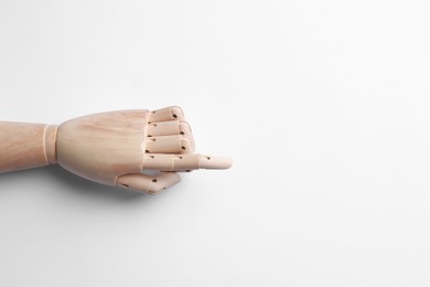 Wooden mannequin hand on white background, top view