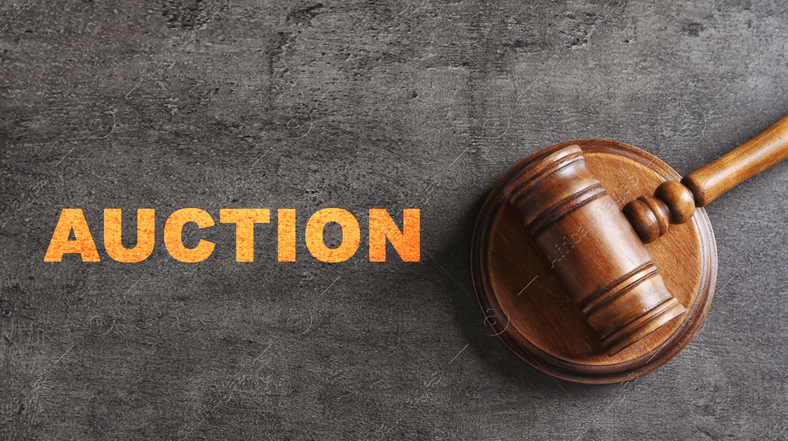 Image of Word Auction and wooden gavel on grey textured table, top view