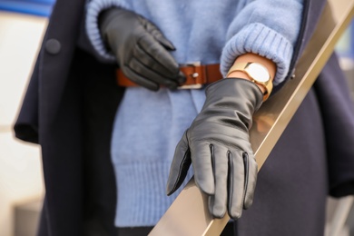 Photo of Young woman in stylish black leather gloves outdoors, closeup