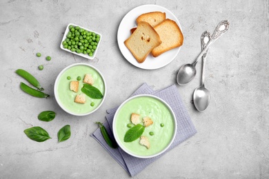 Photo of Flat lay composition with green pea soup on grey background