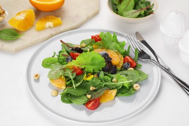 Photo of Delicious salad with tomatoes and orange slices served on white table