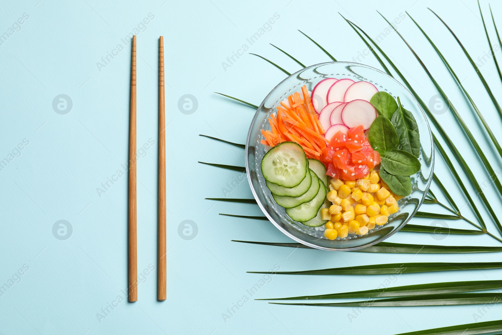 Photo of Delicious salad with salmon and vegetables on turquoise background, flat lay