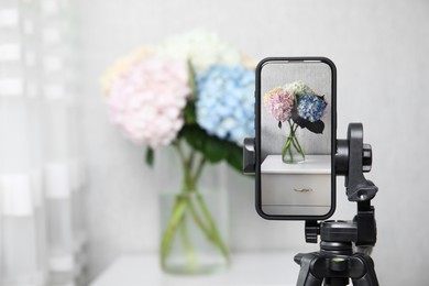 Photo of Taking photo of beautiful hydrangea flowers with smartphone indoors, selective focus