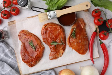 Photo of Flat lay composition with raw marinated meat, rosemary, basting brush and products on white table