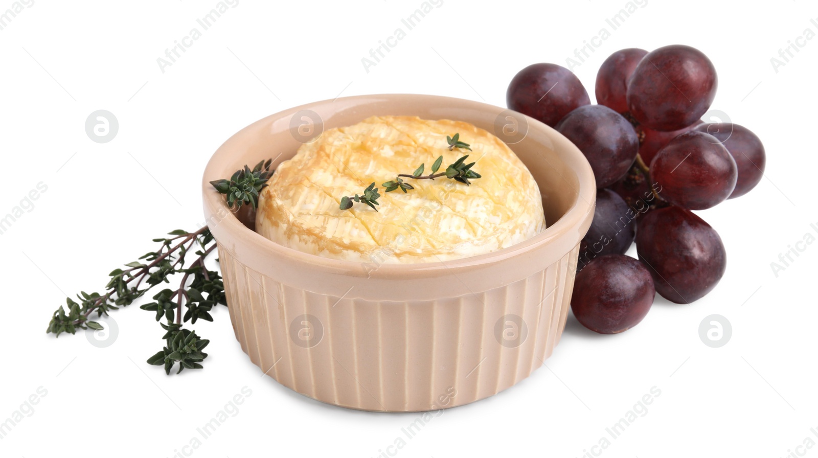 Photo of Tasty baked camembert in bowl, grapes and thyme on white background