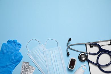 Flat lay composition with medical objects on light blue background, space for text